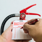 Fire safety first! A photo of a man inspecting a fire extinguisher